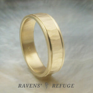 5mm yellow gold men's wedding band with flat profile. Center is hammered with matte finish, and edges are stepped.