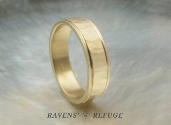 5mm yellow gold men's wedding band with flat profile. Center is hammered with matte finish, and edges are stepped.